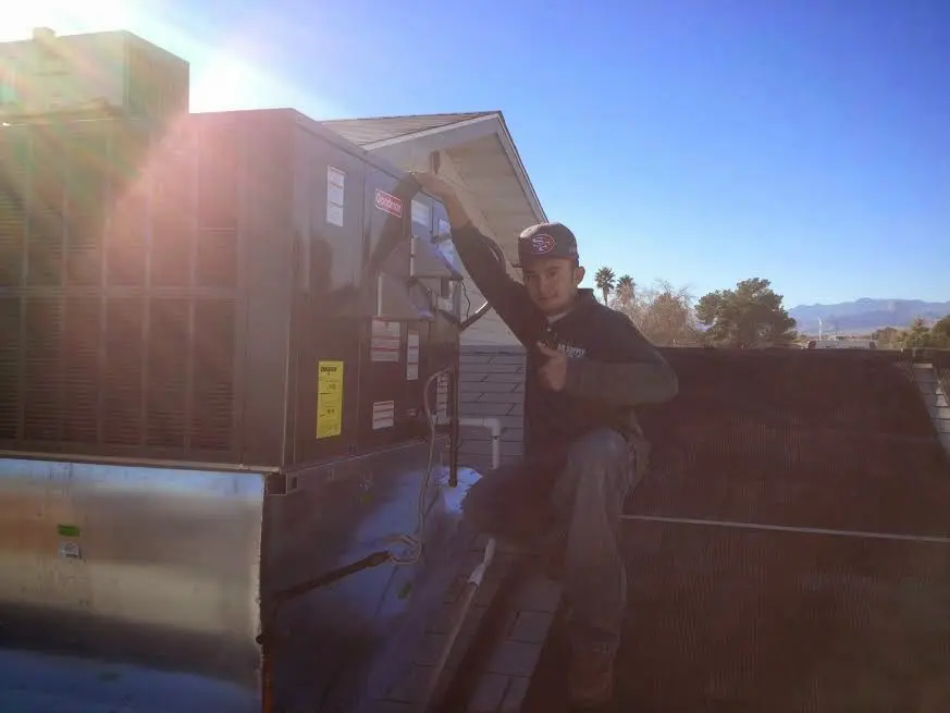 HVAC technician performing Air Duct Repair on a rooftop unit in Sun City